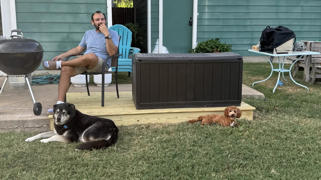 Jose sitting on the first little deck with his dogs nearby